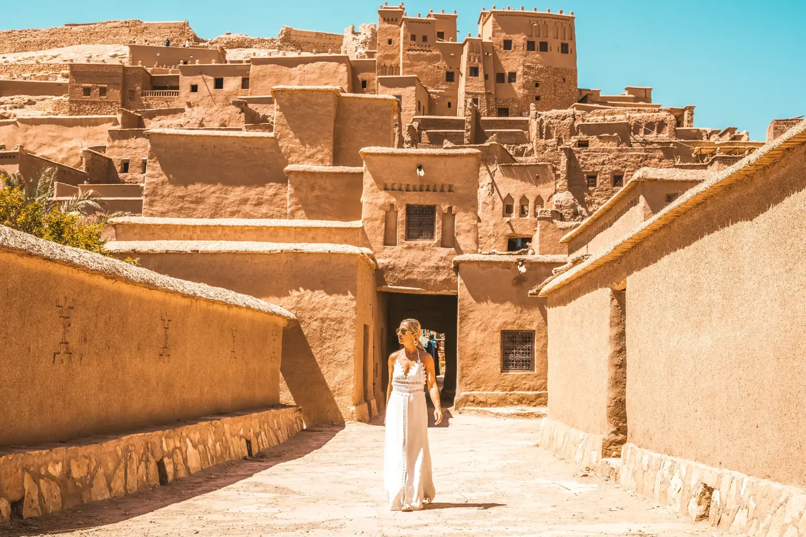 A travel content creator walking through the kasbah of Aït Ben Haddou, Morocco