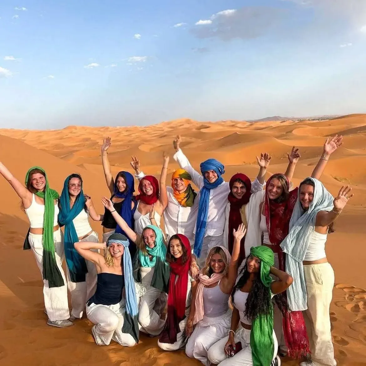 A happy group of travellers on a private Morocco tour in the Sahara