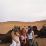 Students enjoying quad biking and sandboarding, camel ride activities in the Erg Chebbi dunes, Merzouga.