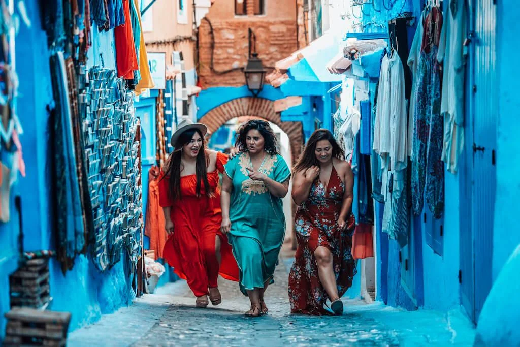 chefchaouen-women-travel Women discovering the blue-painted streets of Chefchaouen, Morocco.